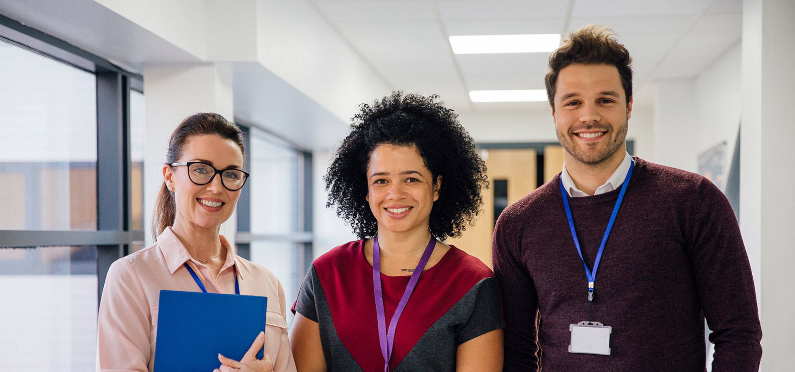 Three teachers in a school hallway